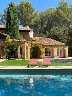 two red chairs sitting next to a swimming pool at Provençal Villa At Domaine in Cornillon-Confoux