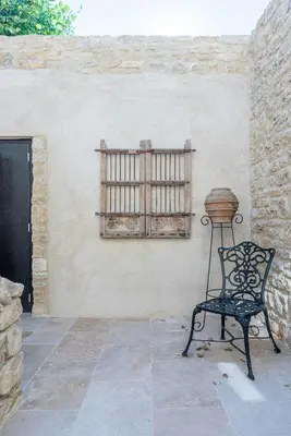 a black chair sitting next to a wall with a window at Five-Bedroom Estate Above Ménerbes Village in Ménerbes