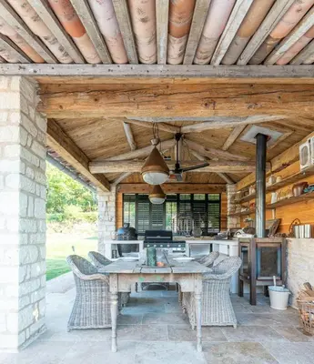 an outdoor kitchen with a table and chairs at Five-Bedroom Estate Above Ménerbes Village in Ménerbes