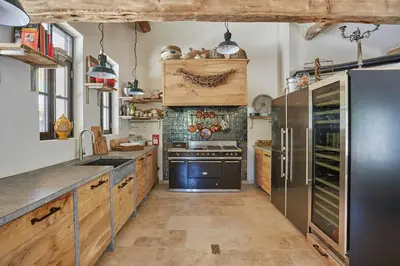 a kitchen with wooden cabinets and stainless steel appliances at Five-Bedroom Estate Above Ménerbes Village in Ménerbes