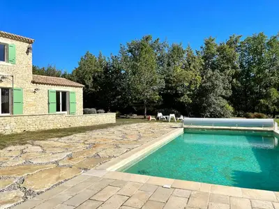 a swimming pool in the backyard of a house at Family Stone House In Gordes in Gordes