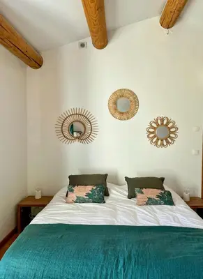 a bedroom with a bed with two mirrors on the wall at Family Stone House In Gordes in Gordes
