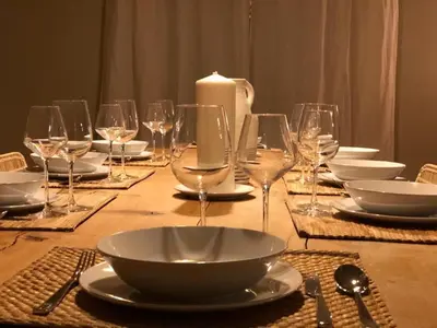 a table with plates and wine glasses and a candle at L'ISLE SUR LA SORGUE - Maison de prestige in Saumane-de-Vaucluse