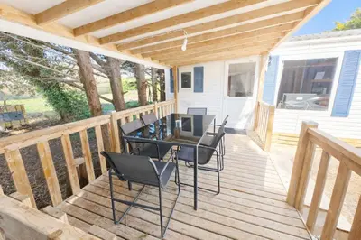 a deck with a table and chairs on it at Mobile Home Pro - 4 personnes et parking in Pélissanne