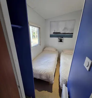 a small room with two beds and a window at Mobile Home Pro - 4 personnes et parking in Pélissanne