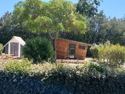 a small cabin in the middle of a garden at Mobil-home 32m² avec terrasse, 3 chambres à Cavaillon, 8 pers. - API-1-52-1384 in Cavaillon