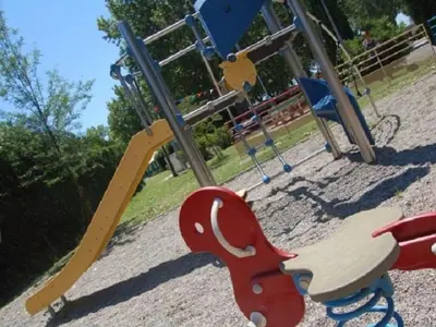 a park with a playground with a slide and a wooden horse swing at Mobil-home confortable, 2 chambres, 4 personnes - API-1-52-1390 in Cavaillon