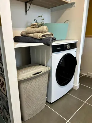 a laundry room with a washer and dryer on a shelf at Maison bord de rivière - Le Thor in Le Thor