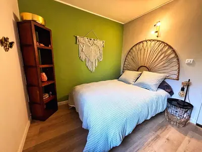 a bedroom with a large bed with a wooden headboard at Maison bord de rivière - Le Thor in Le Thor