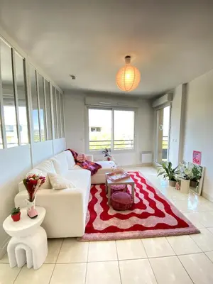 a living room with a white couch and a red rug at Happy appartement in Aix-en-Provence