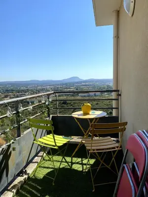 a table and chairs on a balcony with a view at Happy appartement in Aix-en-Provence