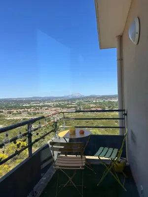 a table and chairs on a balcony with a view at Happy appartement in Aix-en-Provence