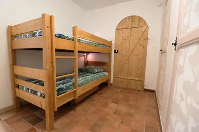 a room with two bunk beds and a door at Gîte Le Relais à Mazan in Mazan