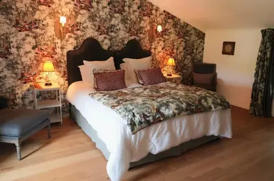 a bedroom with a large bed with floral wallpaper at 19Th-Century Mas With Pool And Garden Facing Luberon in Oppède