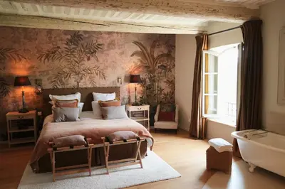 a bedroom with a large bed and a bath tub at 19Th-Century Mas With Pool And Garden Facing Luberon in Oppède
