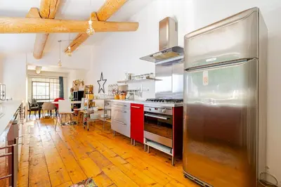 a kitchen with a stainless steel refrigerator and a dining room at Charmante maison de village avec cour intérieure in Bédoin