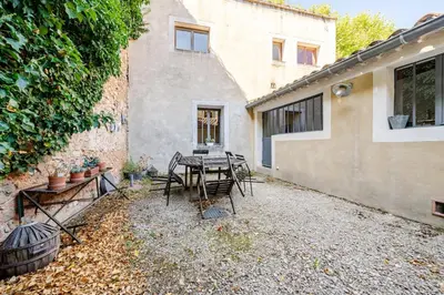 a patio with a table and chairs next to a building at Charmante maison de village avec cour intérieure in Bédoin