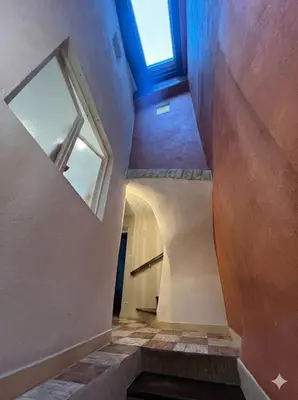 an attic hallway with stairs and a window at Maison de ville climatisée avec toit-terrasse privatif in Monteux