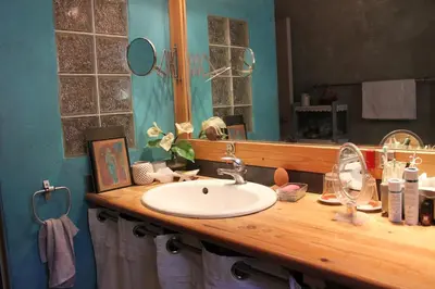 a bathroom counter with a sink and a mirror at Rooms with sculptor in Pinèdes in Aurons