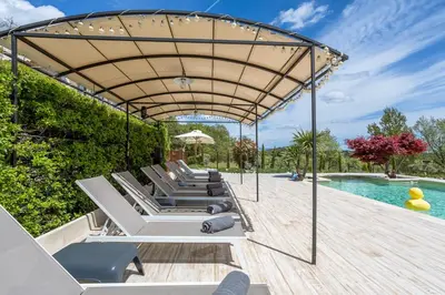 a group of lounge chairs on a deck next to a pool at Bastide Vallonia Luxury & Serenity in the Heart of the Luberon in Murs