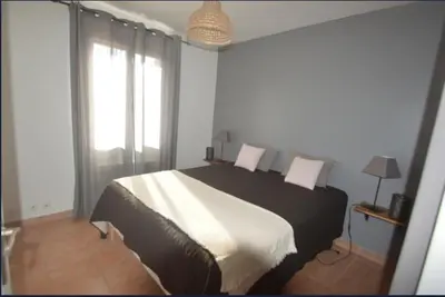 a bedroom with a black and white bed and windows at Les Abricotiers in Caromb