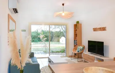 a living room with a couch and a tv at Maison Avec Piscine Privée in Mazan