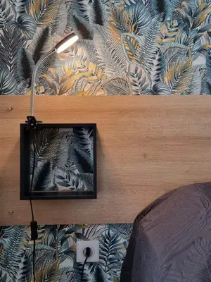 a mirror hanging on a wall next to a bed at Gîtes de la Coupière Le Mûrier in Aubenas-les-Alpes