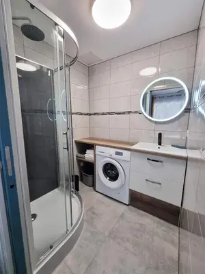 a bathroom with a washing machine and a sink at Gîtes de la Coupière Le Mûrier in Aubenas-les-Alpes