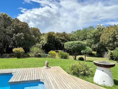 a patio with a couch and chairs and an umbrella at -La Garrigue Paradis-Maison de Vacances entièrement climatisée 5 chambres avec piscine-10 personnes in Rognes