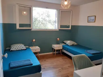 a room with two beds and two tables and a window at Gîte de la Transhumance - 80m2 in Rognes