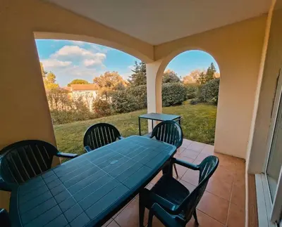 a patio with a table and chairs and a garden at La Durance in Mallemort