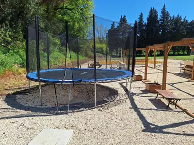 a playground with a trampoline in a park at Apartment Gîte Moulin de Tartay by Interhome in Avignon