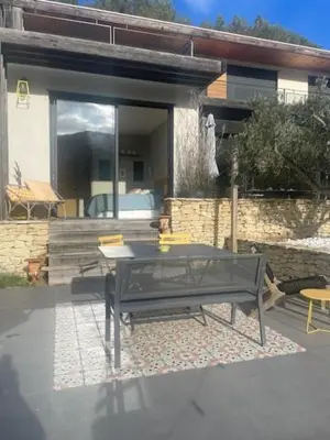 a black table and chairs in front of a house at 1 Brin à part in Maubec