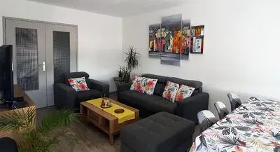 a living room with a couch and a table at Appartement Spacieux avec Balcon in Carpentras