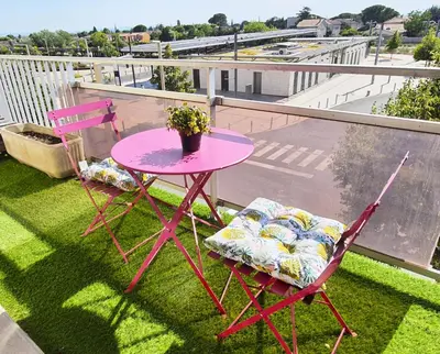 a pink table and two chairs on a balcony at Appartement Spacieux avec Balcon in Carpentras