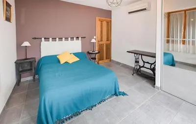 a bedroom with a bed with a blue blanket at Maison Avec Piscine 1 in Mormoiron