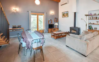 a living room with a table and a couch at Maison Avec Piscine 1 in Mormoiron