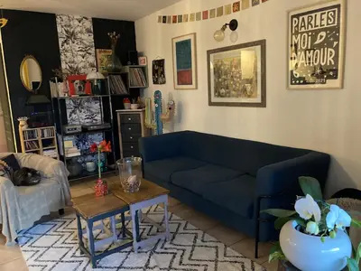 a living room with a blue couch and a table at Charmant appartement velleron in Velleron