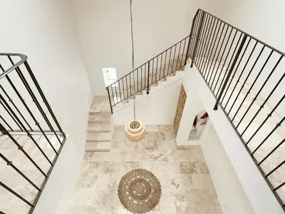 a hallway with stairs and a rug on the floor at Le Mas des Poètes in Saint-Andiol