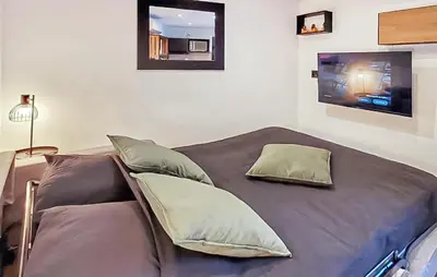 a bed with pillows and a tv in a room at Nice Home In Jonquerettes in Jonquerettes