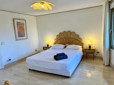 a bedroom with a large white bed with a wooden headboard at Air-conditioned Provençal country house with pool in Jouques