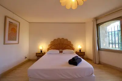 a bedroom with a large bed with two lamps at Air-conditioned Provençal country house with pool in Jouques
