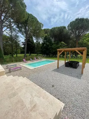 a swimming pool with a wooden pergola and a swimming poolvisor at 4-bedroom house with a pool in LʼIsle-sur-la-Sorgue