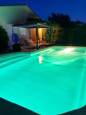 a swimming pool at night with blue lights at Les hirondelles Piscine privée climatisation billard calme 4 lits in LʼIsle-sur-la-Sorgue