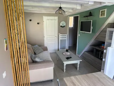 a living room with a couch and a table at Dépendance de charme avec piscine en luberon in Peypin-dʼAigues