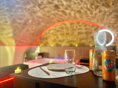 a table with a plate and a glass on it at Secret LoveRoom - SpaBalnéo, Lit King Size, CLIM, Chic, calme et discret, 2 personnes in Saint-Chamas