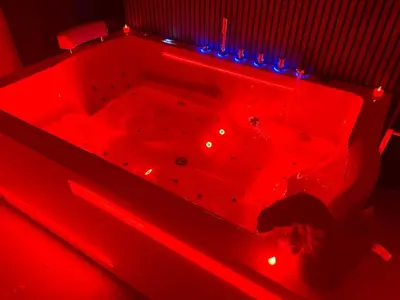 a red bathtub with blue lights in a room at Secret LoveRoom - SpaBalnéo, Lit King Size, CLIM, Chic, calme et discret, 2 personnes in Saint-Chamas