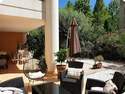 a patio with an umbrella and chairs and a table at Appartement 3 pièces Aix-en-provence in Aix-en-Provence