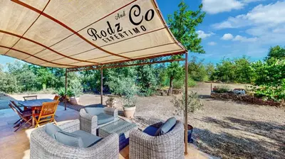 a patio with a table and chairs and an umbrella at gite de charme au pied du luberon avec piscine privée à Apt en Provence in Apt