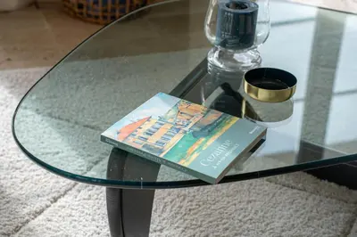 a book sitting on top of a glass table at Aurenza - Piscine - Jardin paysager - Vue campagne in Éguilles